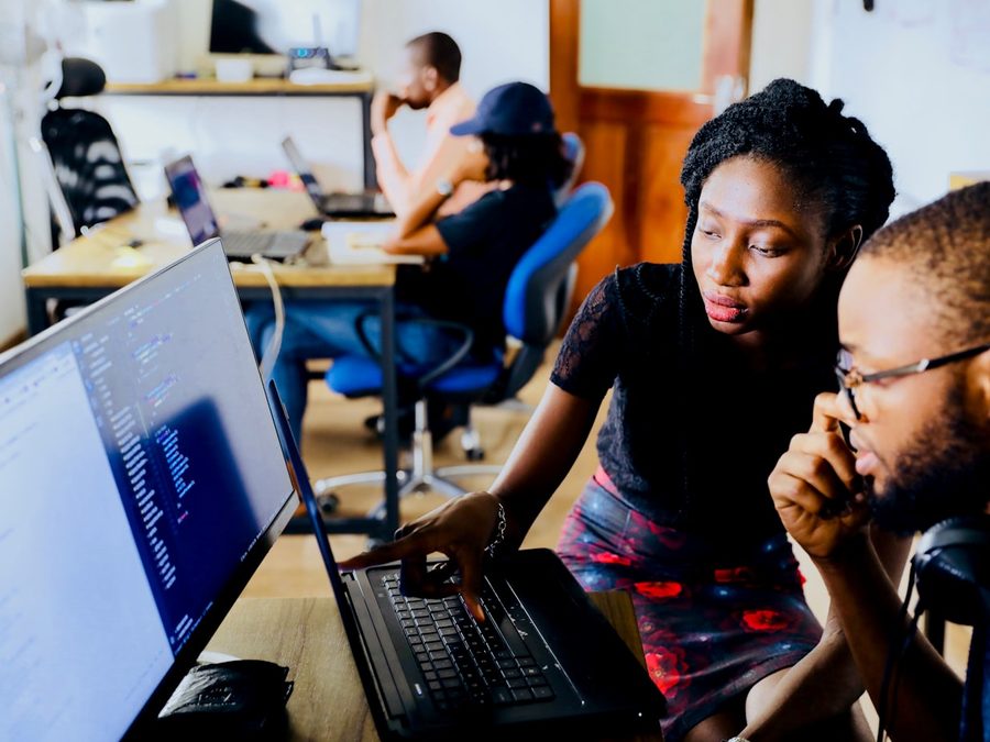 Two people reviewing work together on a computer screen